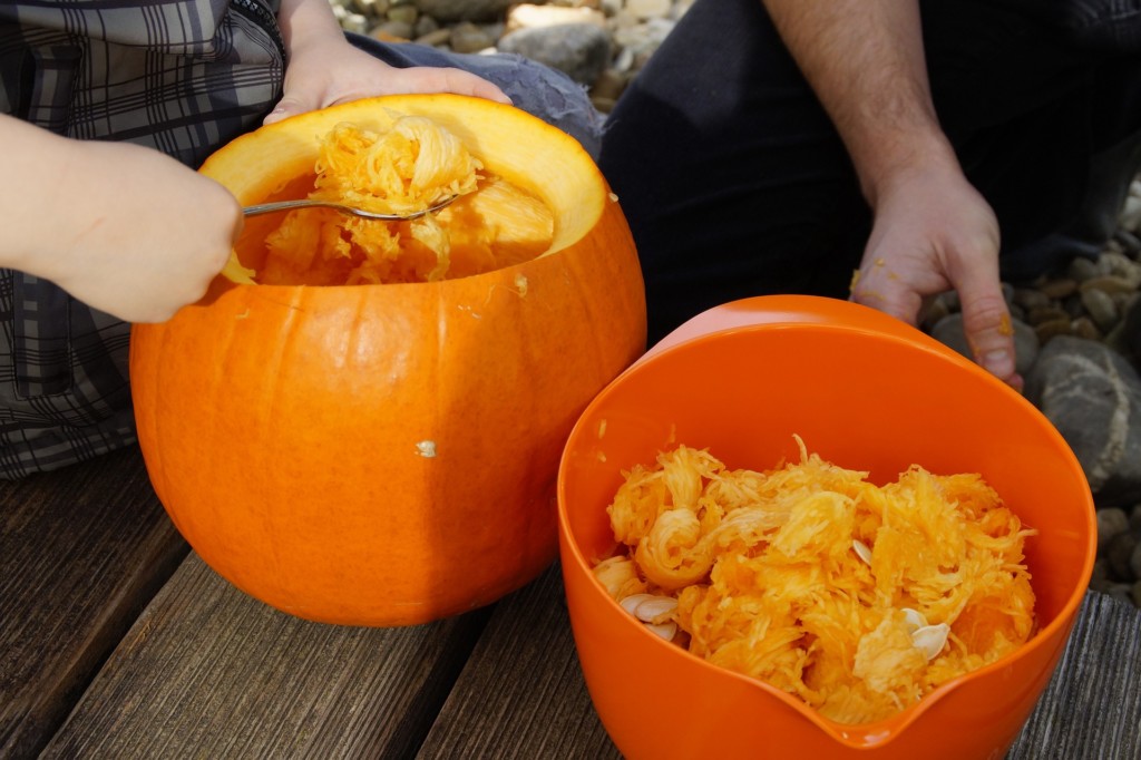 Volunteers scooping pumpkin guts during a carving event — a hands-on festival activity.
